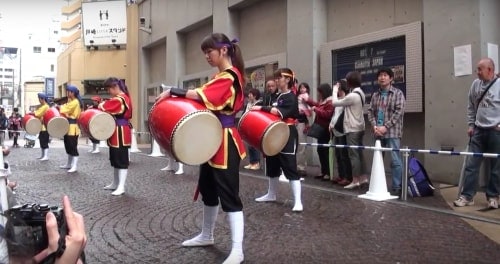 Okinawa Eisa festival: Ladies dressed in red and black playing taiko drums