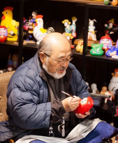 The craftsman is painting daruma