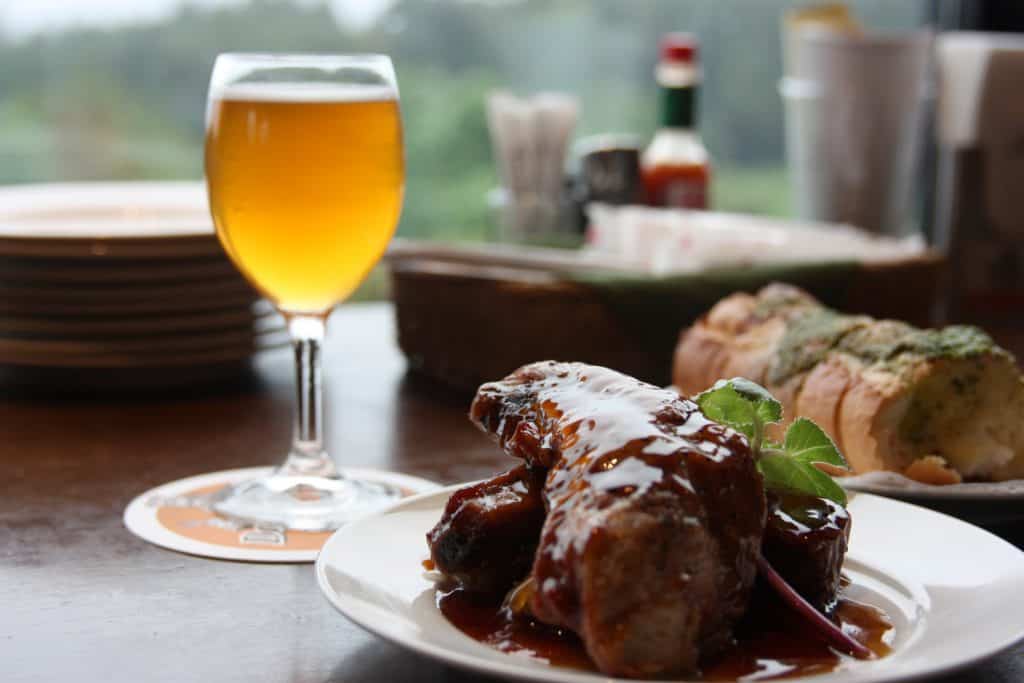 meat dish next to glass of beer in a japanese restaurant and bar