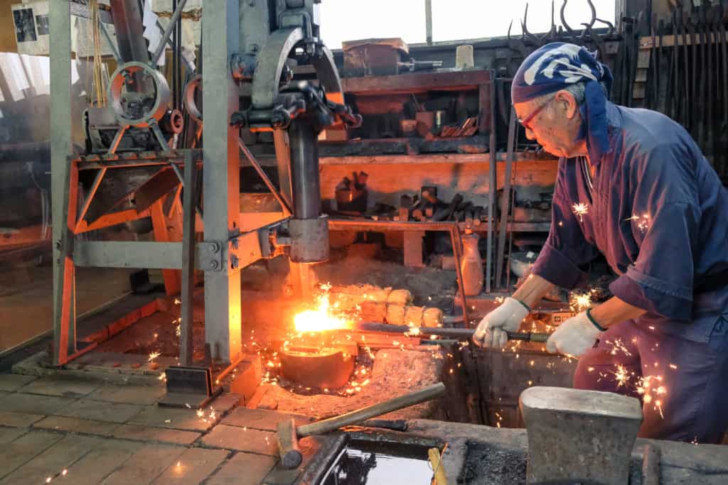Hammering the impurities out of iron in making a traditional Japanese sword in Kumamoto