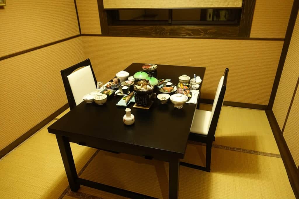 Private dining room of the ryokan where a traditional kaiseki meal is placed on the table