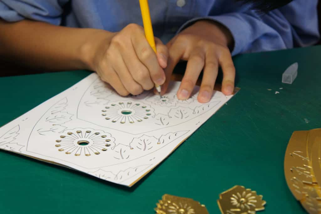 Hads of a craftman, cutting paper to make a Yamaga lantern