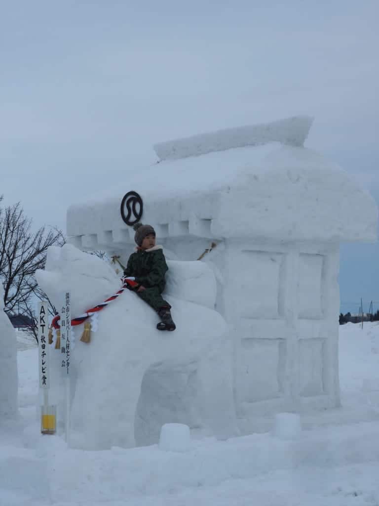 A child on an Akita dog sculpture at the Inukko Matsuri Festival