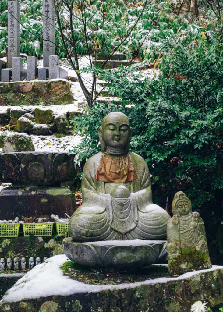 Small statues with snowy background in Japan