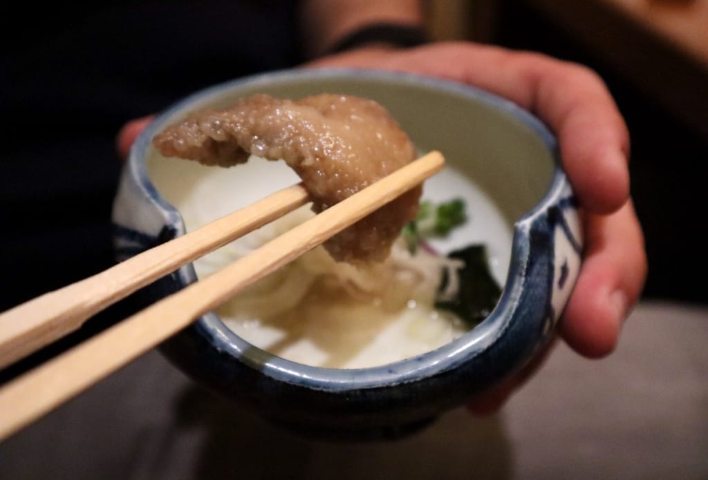 Chilled fried fish with a sweet vinegar marinade being eaten with chopsticks