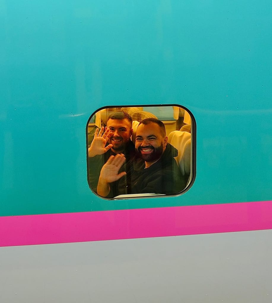 Mark and Jonathan waving from window of Shinkansen