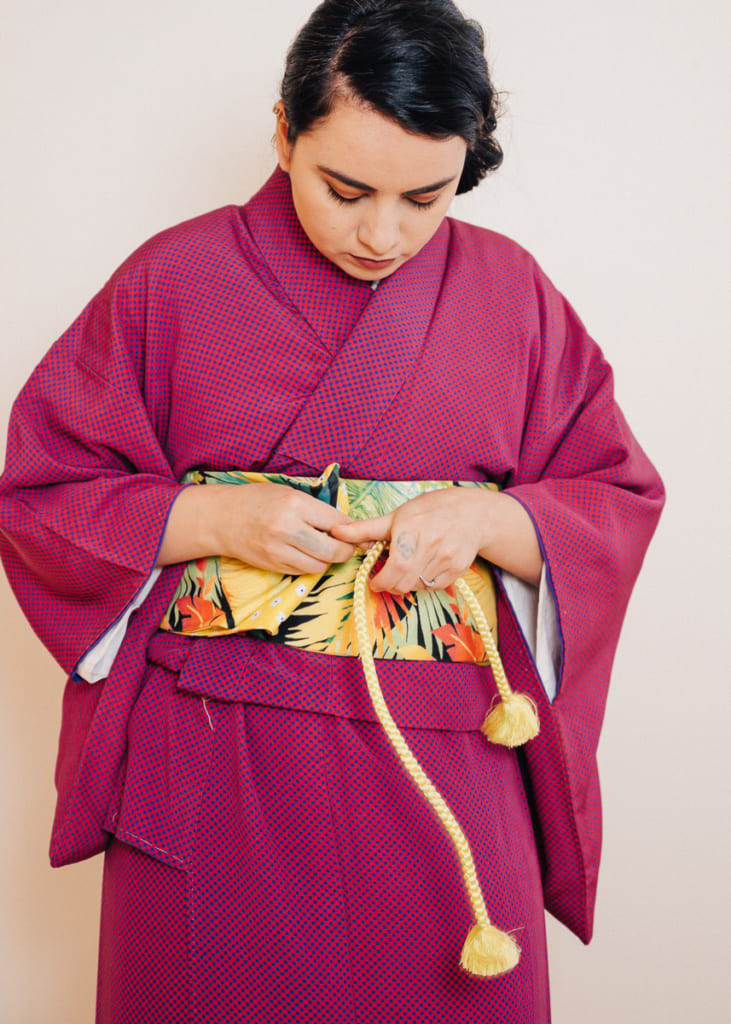 make a pattern or folds at the end of the hanhaba obi