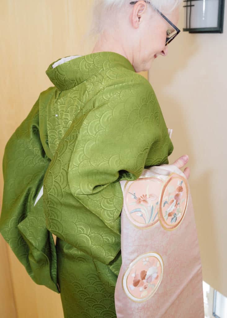 hold the thick end of the obi in the crook of your right arm