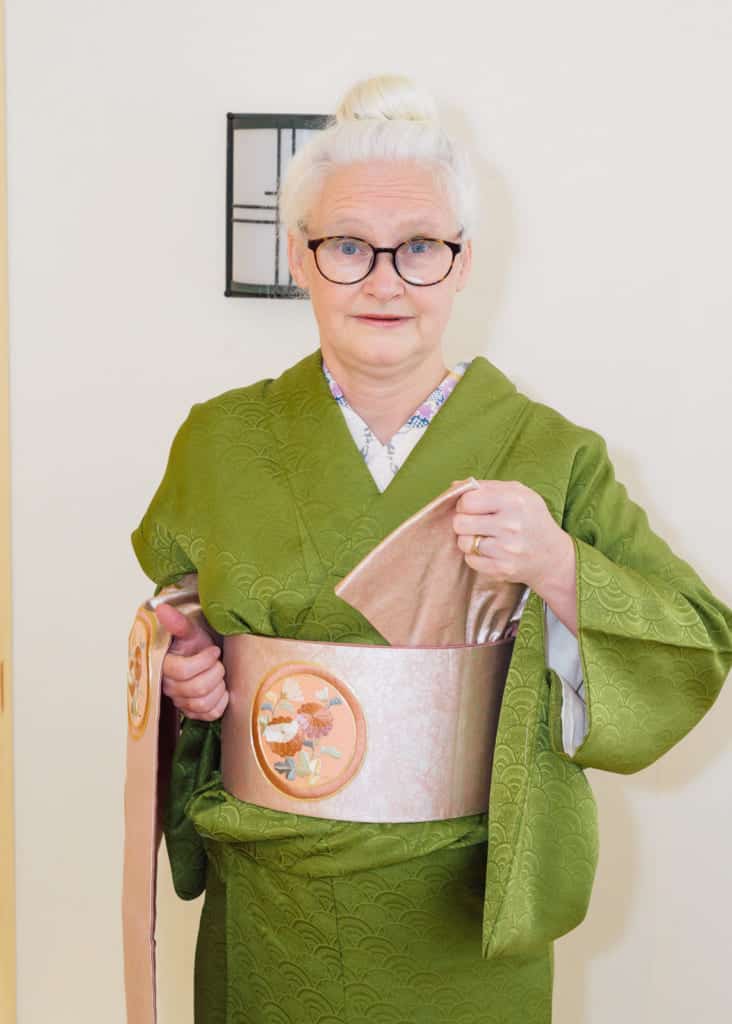 free the narrow end of the obi with your left hand by pulling up and away from your body