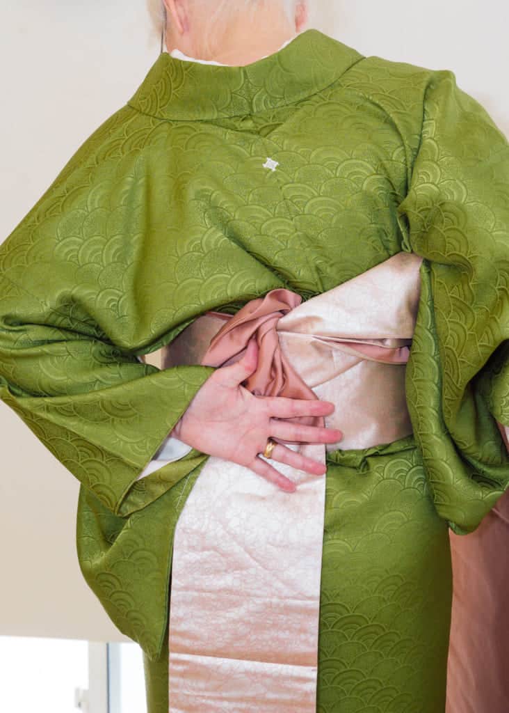 hold the obi in place with the back of your left hand