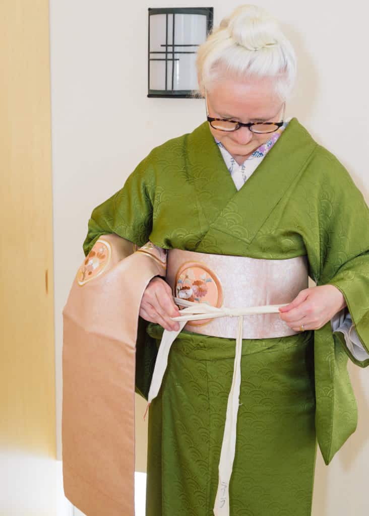 tie the koshi-himo around the obi to temporarily hold it in place