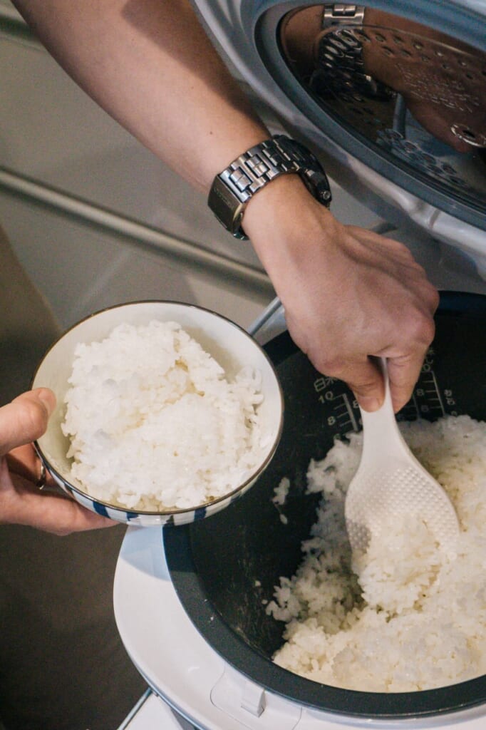 Taking out some rice from the rice cooker