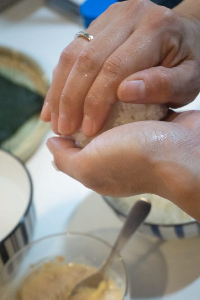 Give the deserved shape of the onigiri with your hands