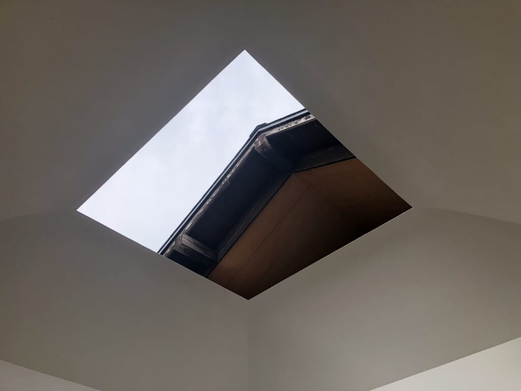 The hole in the roof of James Turrell's House of Light showing the sky and part of the traditional Japanese building