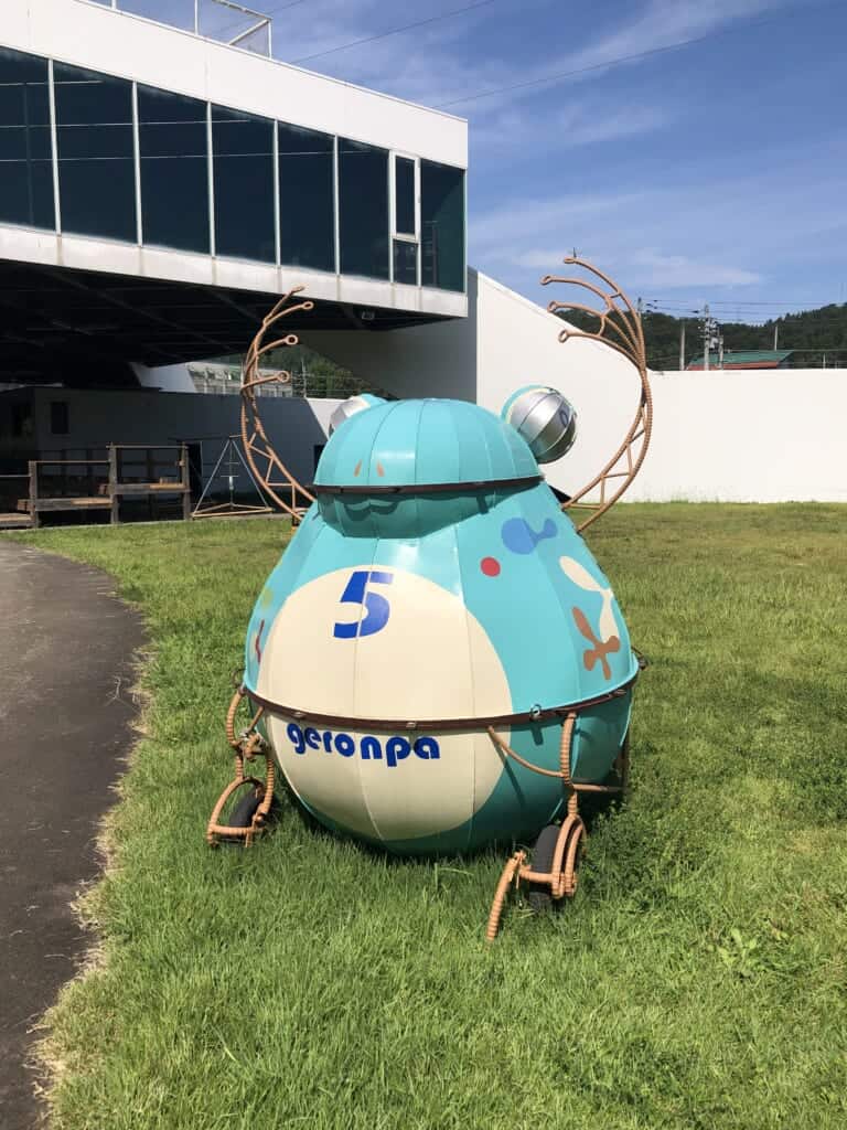 An artwork representing a blue frog made of metal