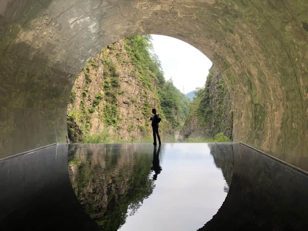 Someone standing in the Tunnel of Light, with reflexion on the water ground, Niigata