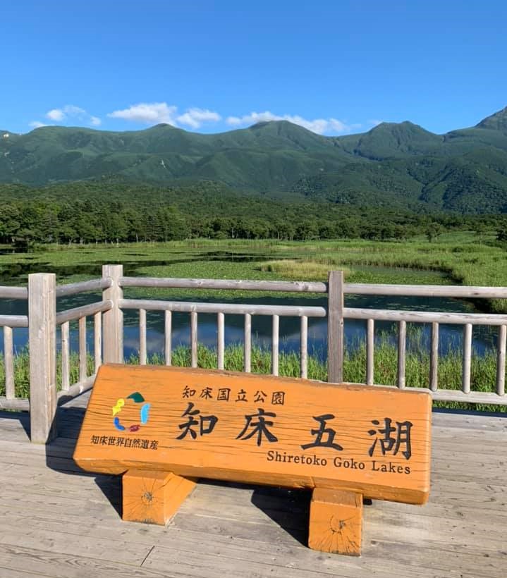 Signboard and overview on the Five Lakes landscape, mountains in the background