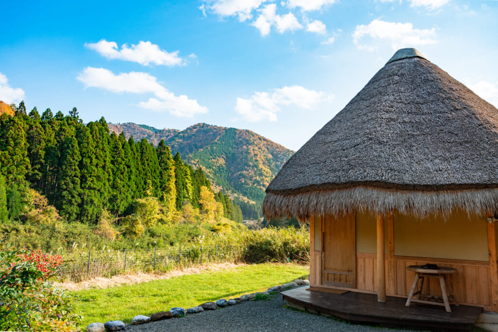 Mountain view with traditional Japanese thatched roof house in Miyama