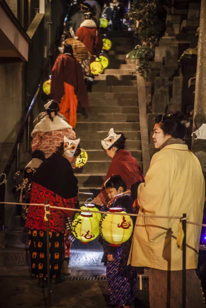 foxes climbing the stairs of Oji Inari Jinja