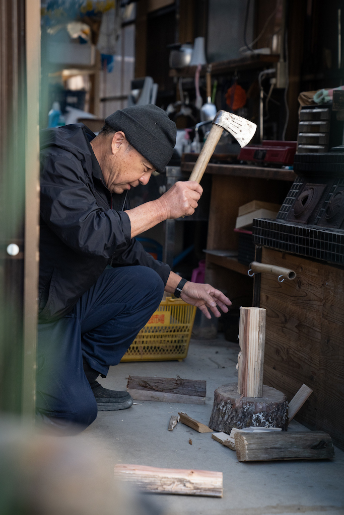 Mr. Ogura chops wood with an axe