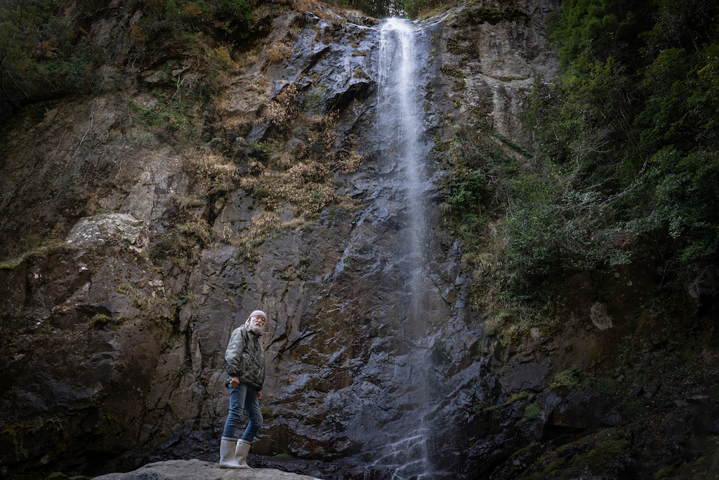Mountain hermit under waterfall