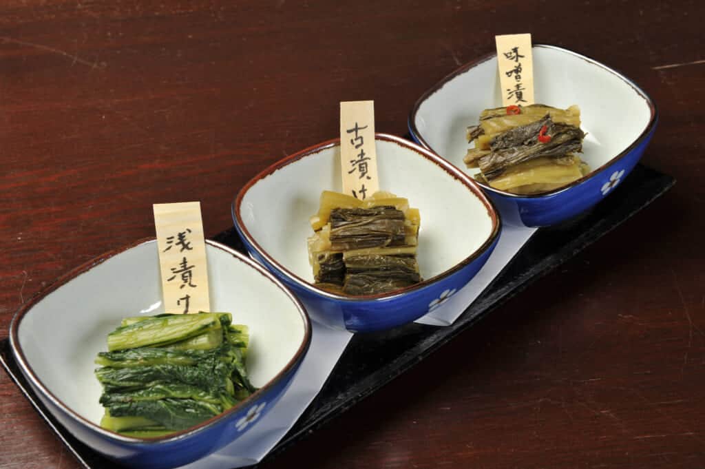 three small dishes of marinated vegetables