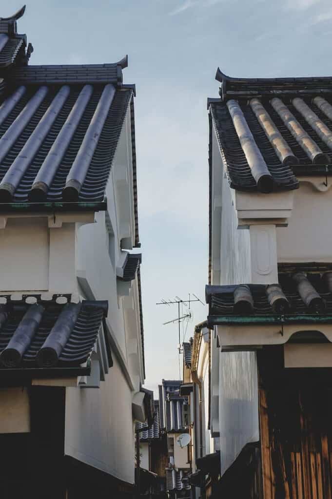 Two traditional Japanese houses with tiled roofs separated by a narrow alley