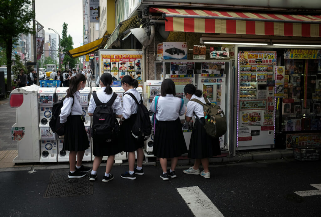 Girls in front of some gachapon machines in Akihabara