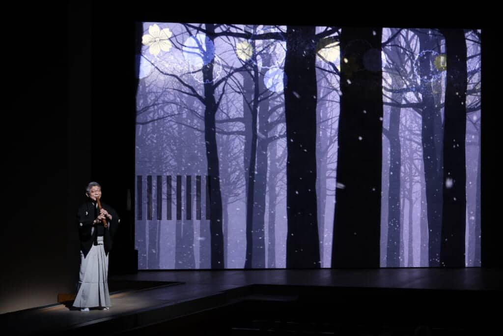 Man playing shakuhachi bamboo flute on stage