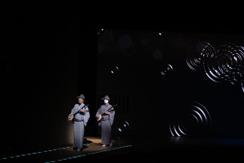 Two people playing shamisen