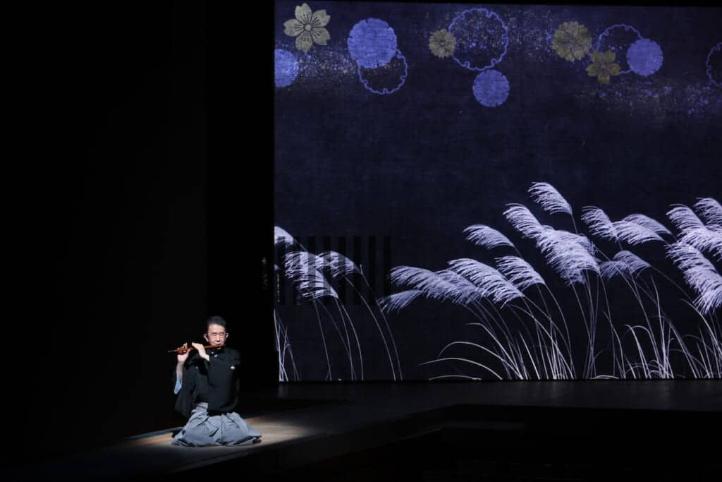 Man playing a bamboo flute on stage