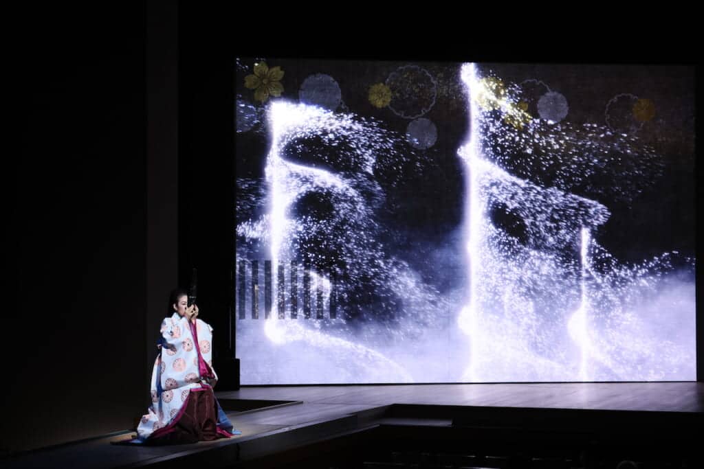 Woman playing Japanese sho instrument on stage for Kabuki performance