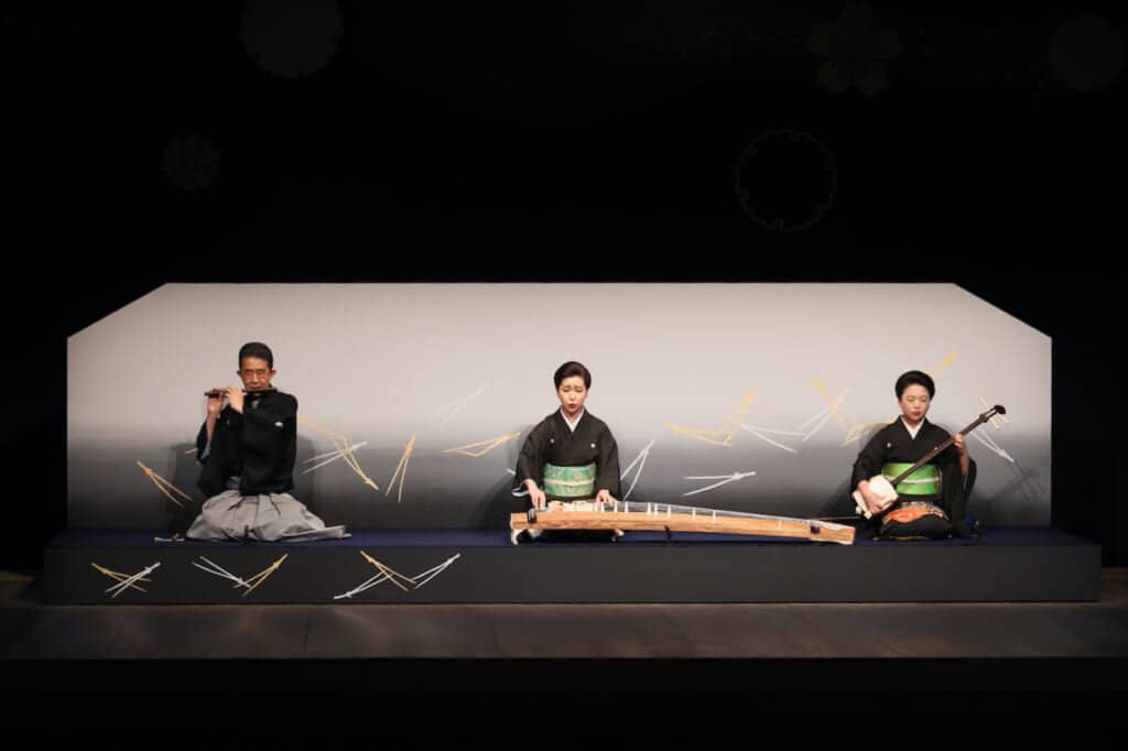 3 musicians playing bamboo flute, koto and shamisen