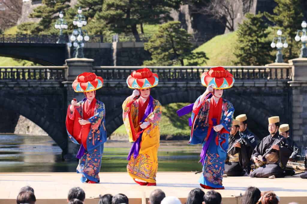 3 traditional Ryukyu dancers in bright costumes in Japan