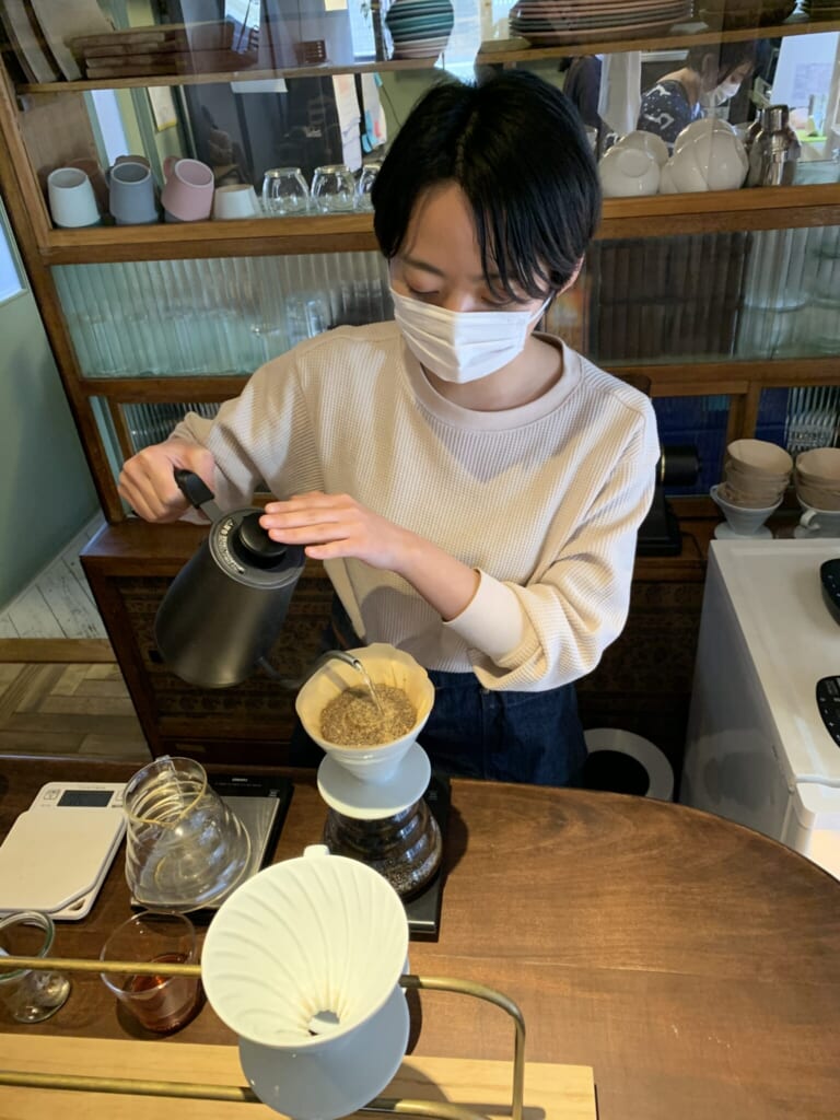 a young man pours hot water to infuse a therapeutic tea in Japan