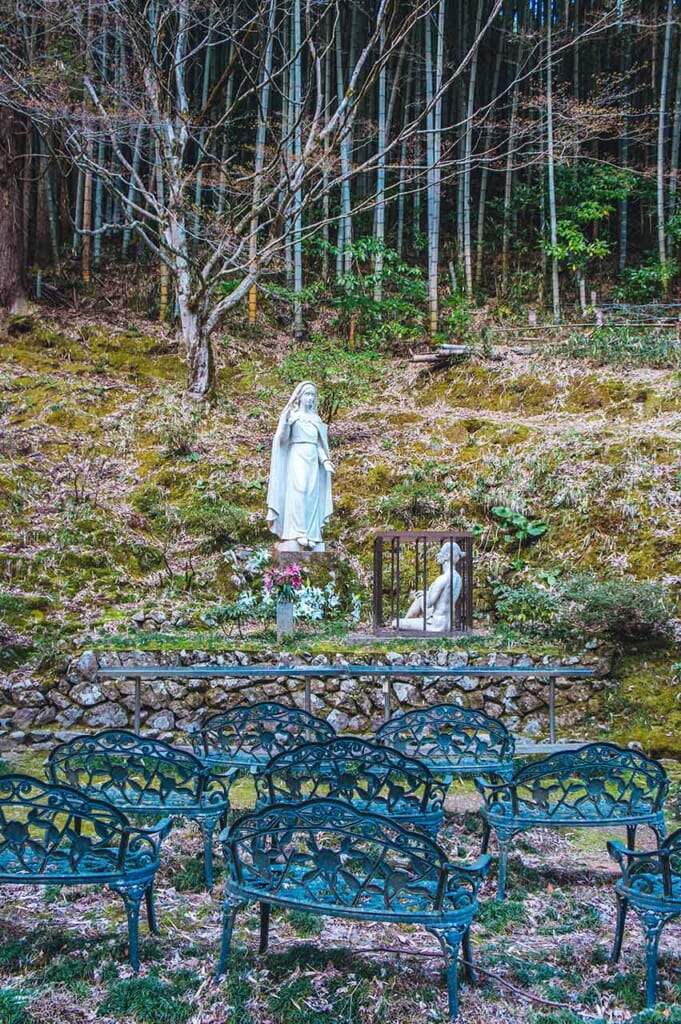 White Christian statue in the Japanese woodland