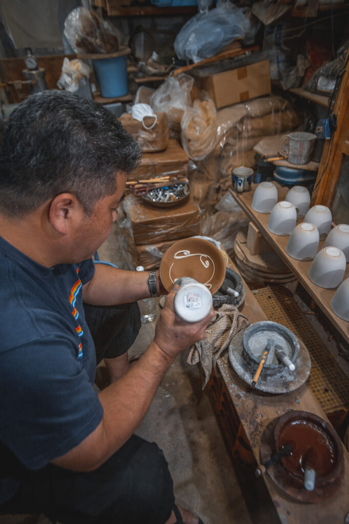Nakama-san decorating handmade ceramic in Okinawa, Japan