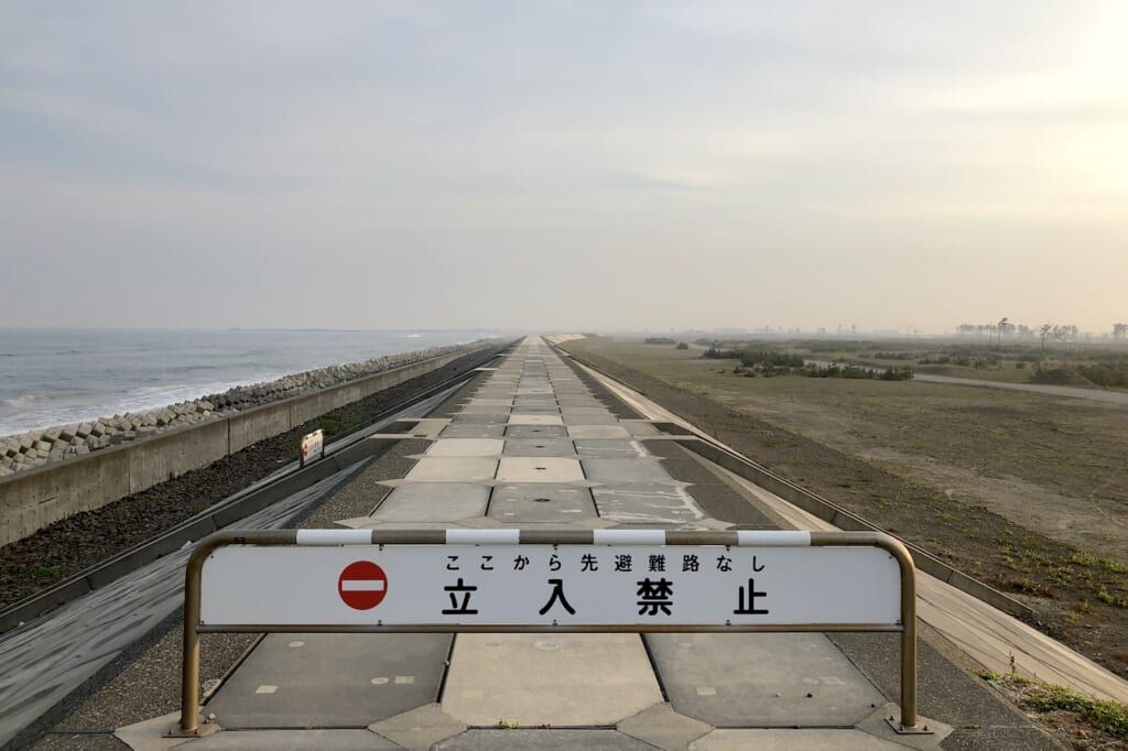 No Entry sign on Japanese seawall stretching out to horizon in Tohoku region of Japan, a lasting memorium of the 2011 Tsunami