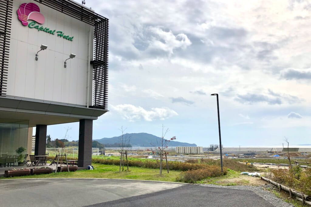 Capital Hotel foregrounded against sea coast