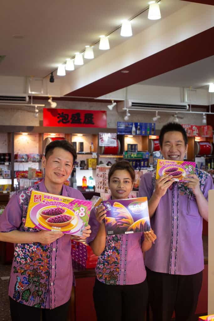three people showing boxes of benimo tart in Okinawa, Japan