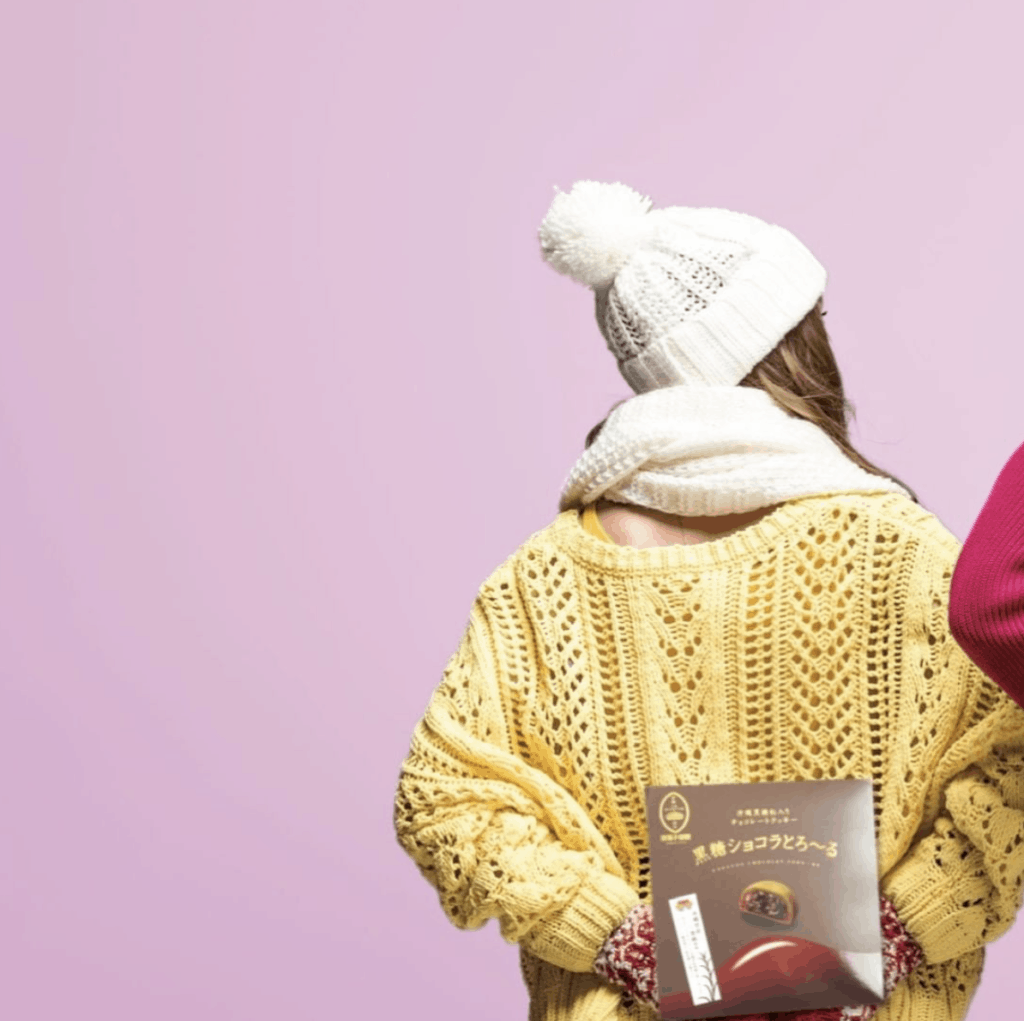 a woman holding a Japanese snack box