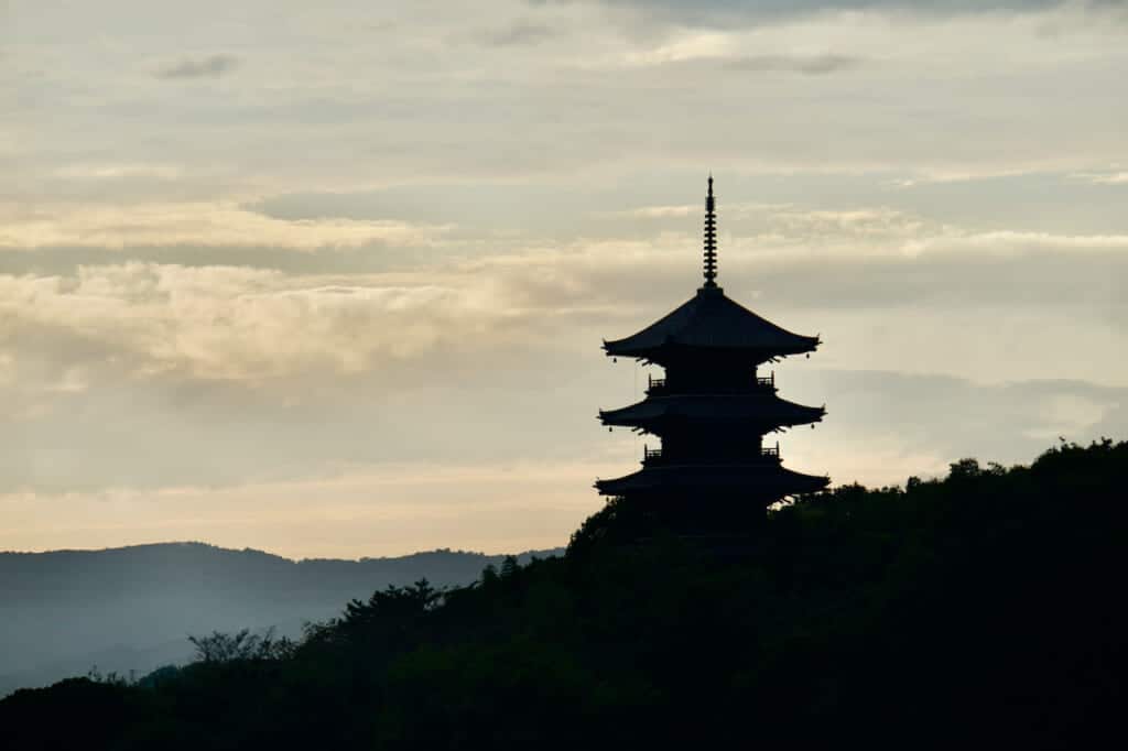 silhouette of Japanese pagoda in forest
