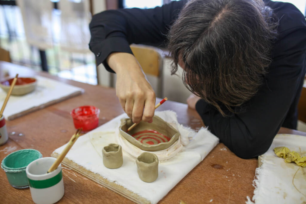 Man painting shaped clay in Japan