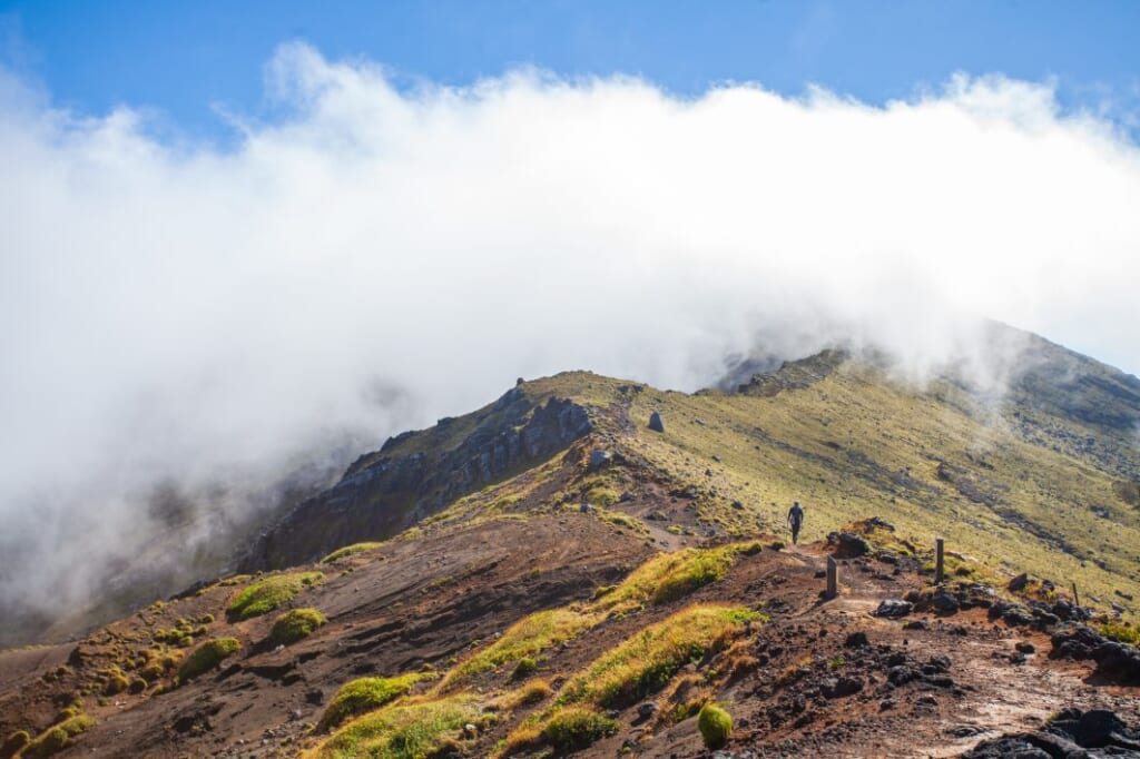 Hiker along a cloudy trail on Mount Asoin Japan