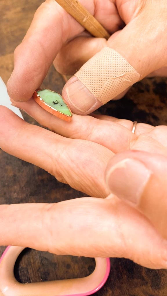 two hands holding a stained glass keychain
