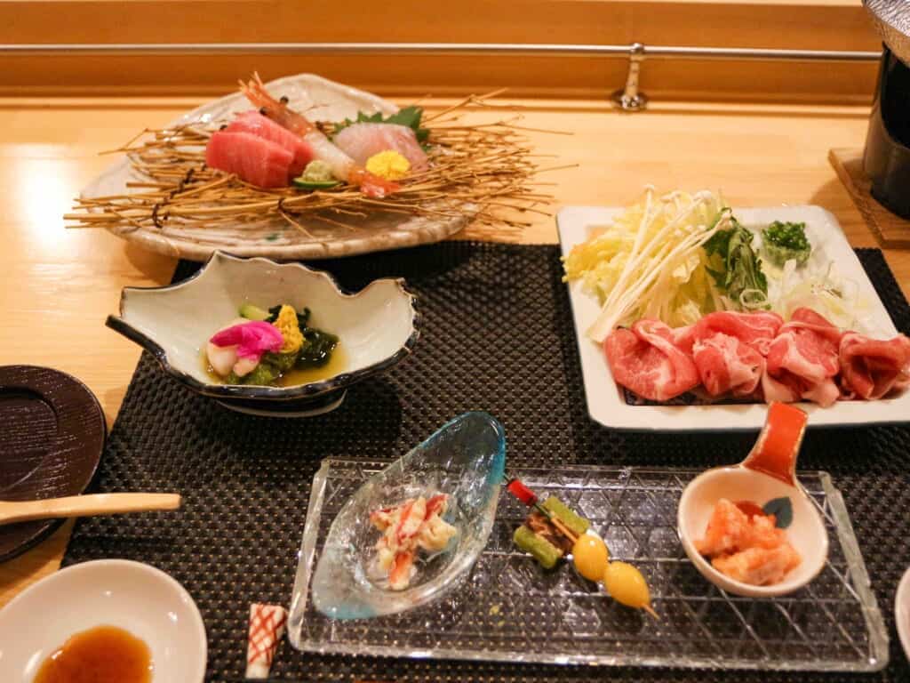 dinner meal set including sashimi and various seasonal vegetables
