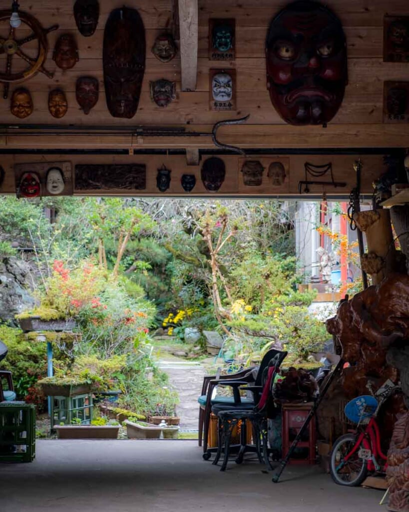 Japanese garage with large noh masks and view of a garden in Kagoshima, Japan