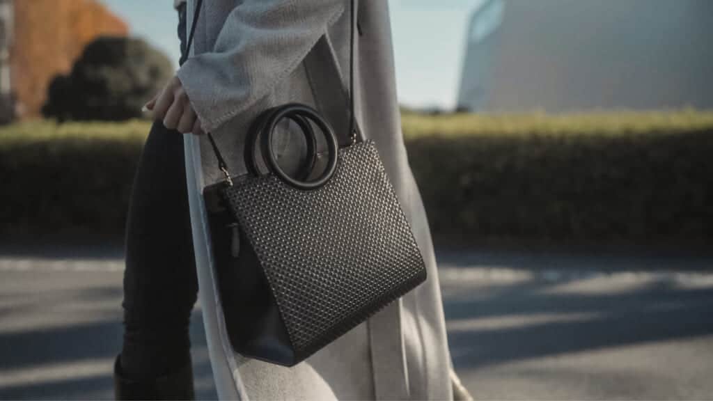 person with a black leather handbag