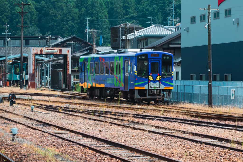 blue train running on railroad tracks