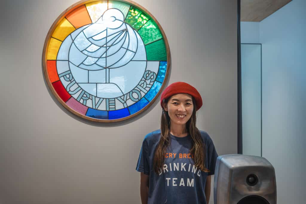woman wearing a beret next to a stainglass window in japan